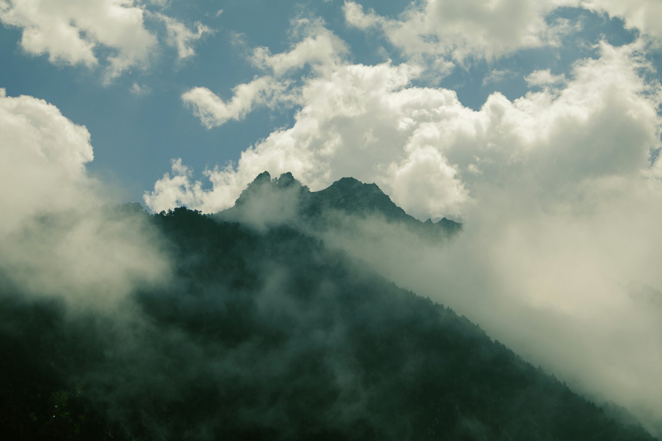Mountain ridge rising through low cloud